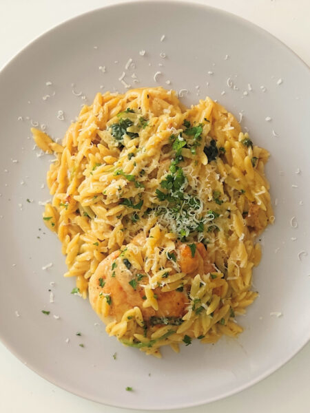 Kremowy makaron orzo z mięsem i pieczarkami, podany w jednej patelni, z dodatkiem szpinaku i suszonych pomidorów – szybki i sycący obiad rodzinny