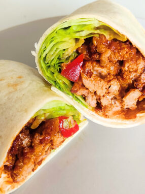 tortille przeciete na pół, mięso, sałąta i pomidor