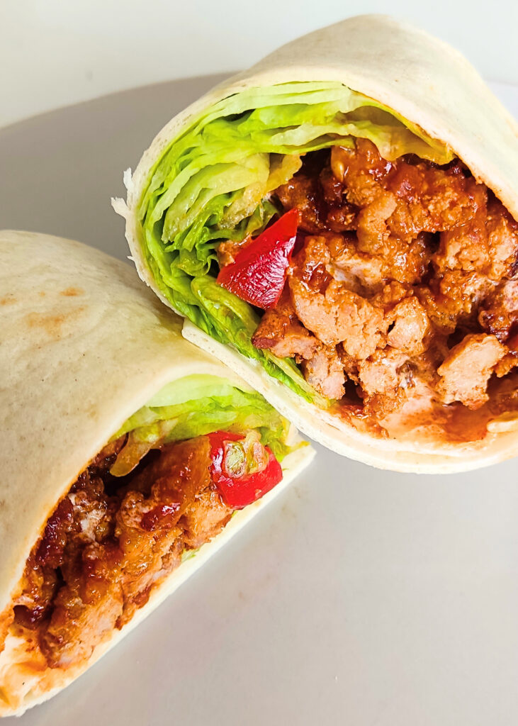 tortille przeciete na pół, mięso, sałąta i pomidor